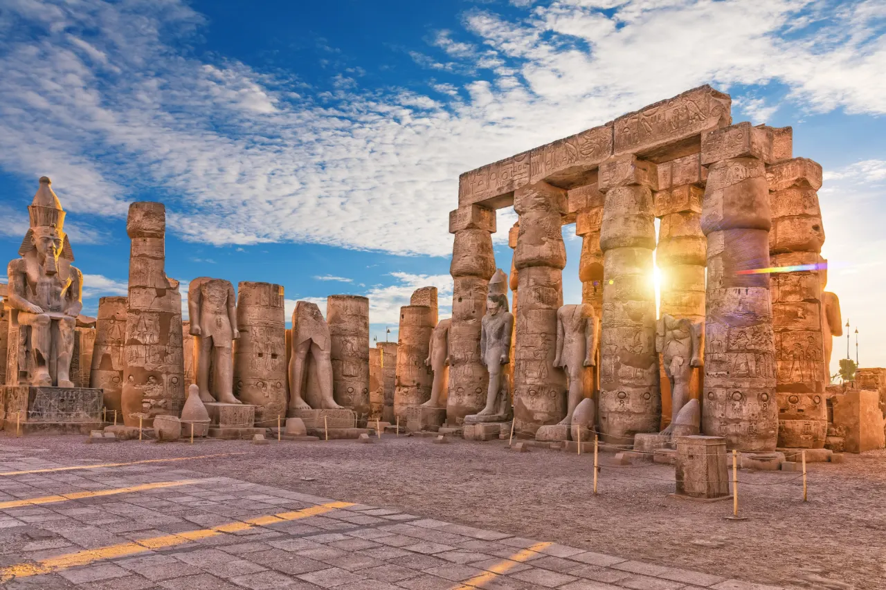 The colonnade and colossal statues of Luxor Temple in low evening sun