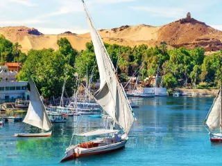 Feluccas on the Nile at Aswan beneath desert hills