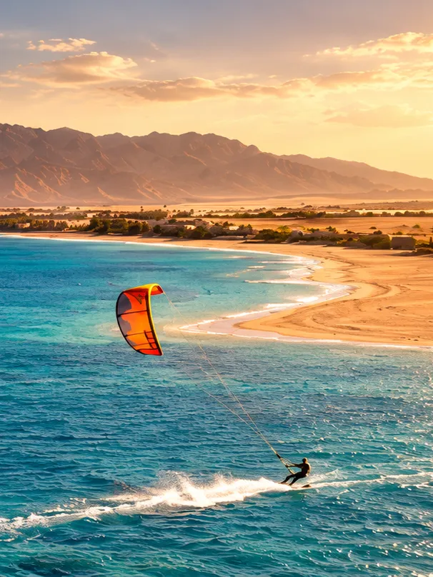 A kitesurfer crossing the Red Sea off a sandy bay near Safaga at sunset