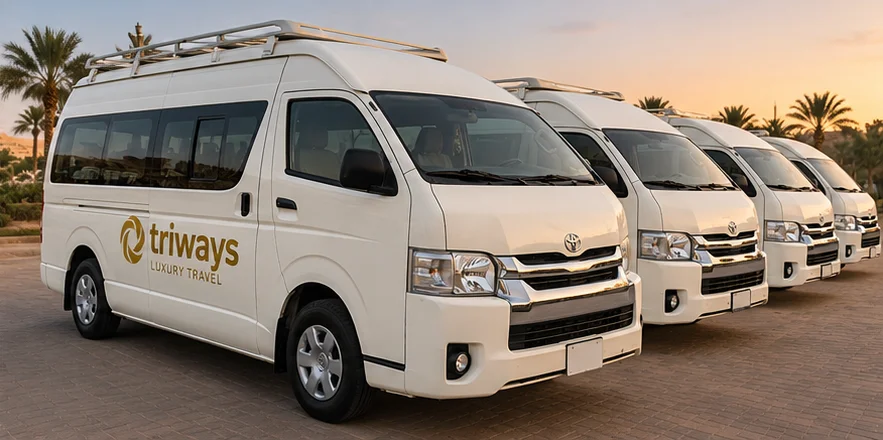 White Toyota Hiace high-roof vans in Triways livery lined up at dusk
