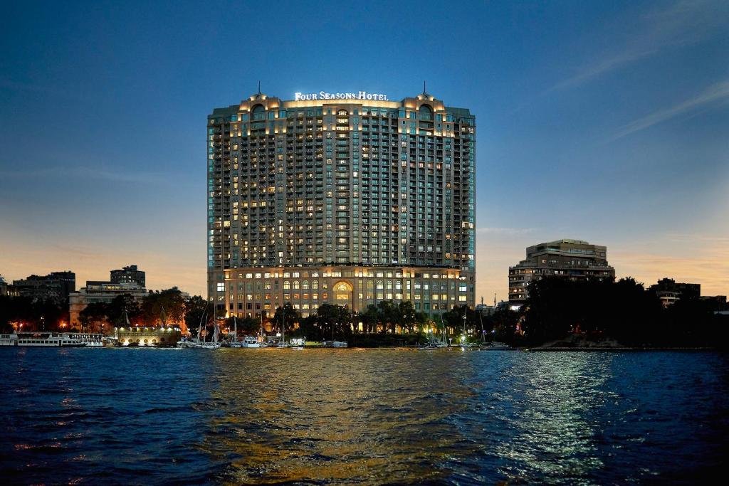 Four Seasons Hotel Cairo at Nile Plaza lit at dusk beside the Nile